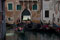 gondolas on a canal in front of a building with one containing tourists